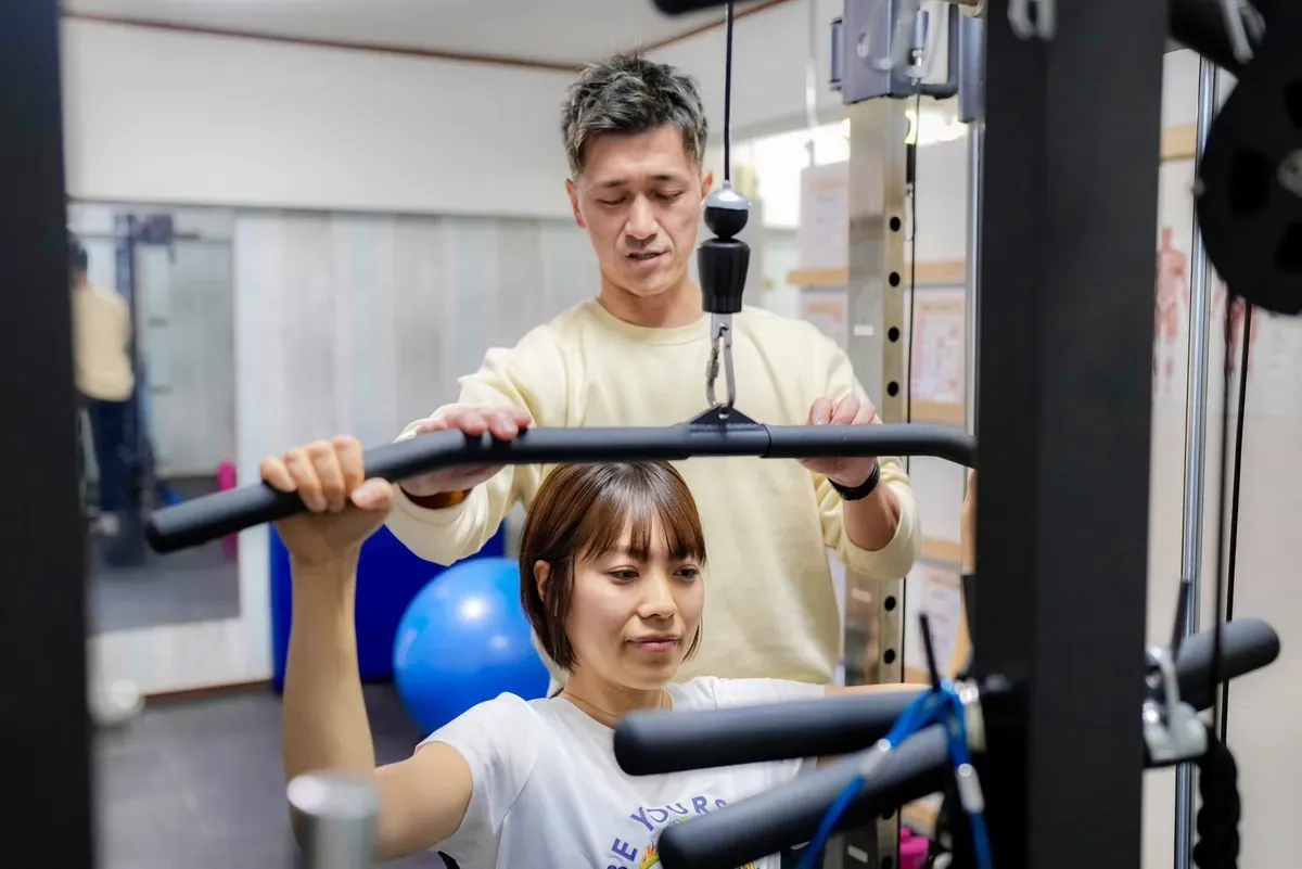 ラットプルダウンを指導する原さん