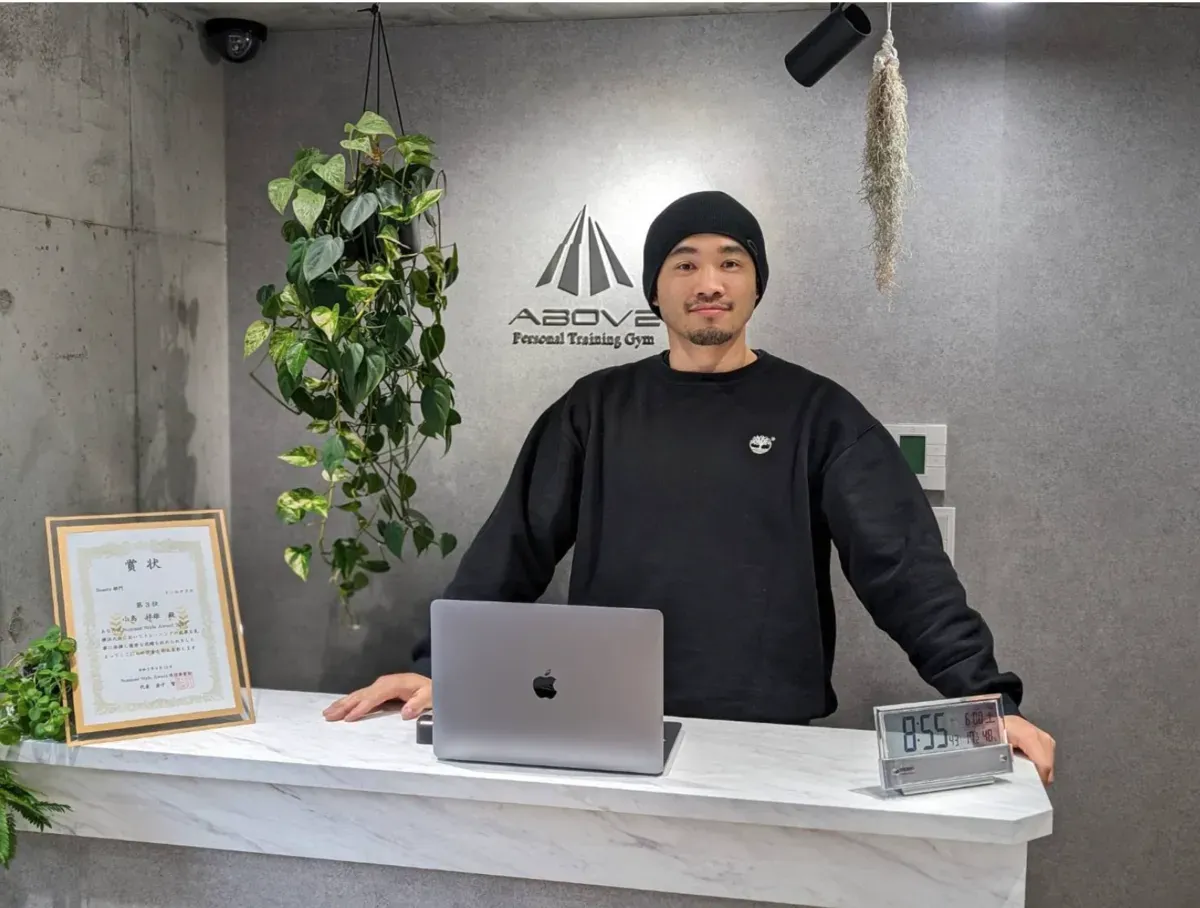 ABOVE の受付に立つ代表・小島 祥雄さん