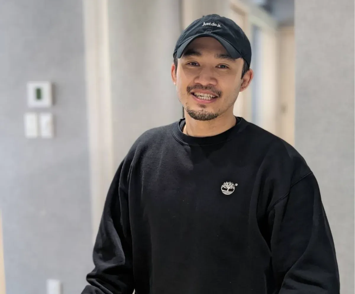 黒いキャップとスウェット姿の小島さん